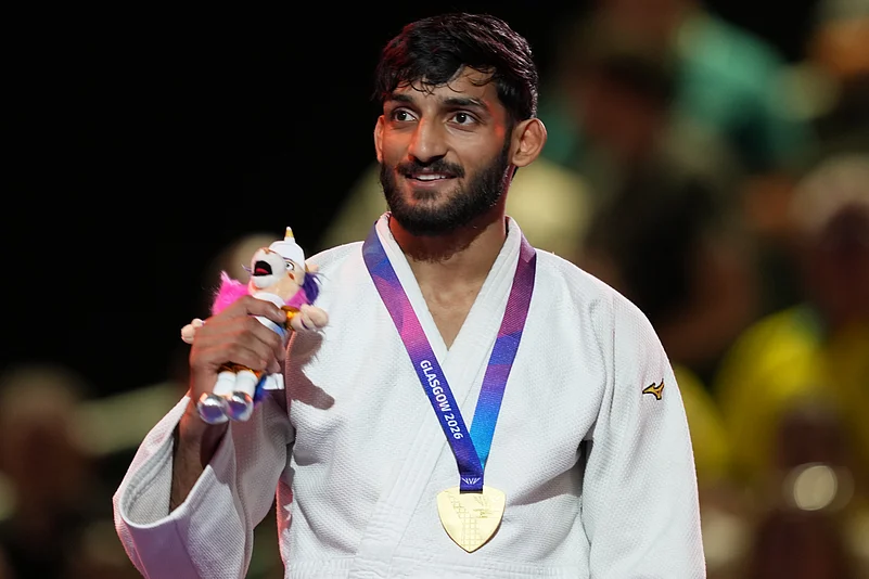 हर्ष सिंह कॉमनवेल्थ गेम्स 2026 जूडो 60kg स्वर्ण पदक व मैस्कॉट के साथ विक्ट्री स्टैंड पर (Harsh Singh CWG 2026 Gold Medalist with Mascot)